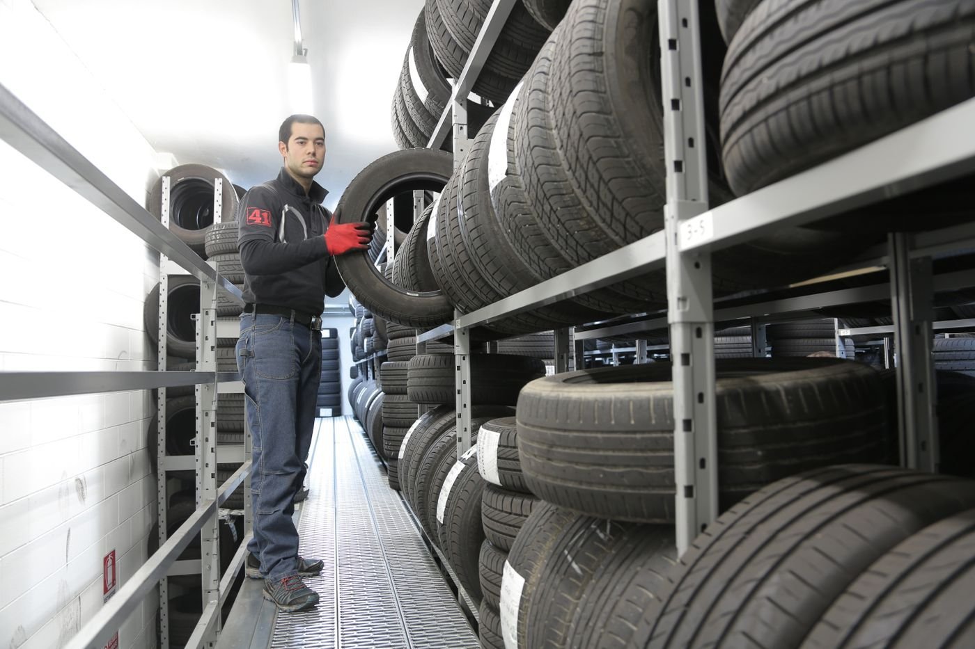 Employé rangeant un pneu dans un rack d'entrepôt